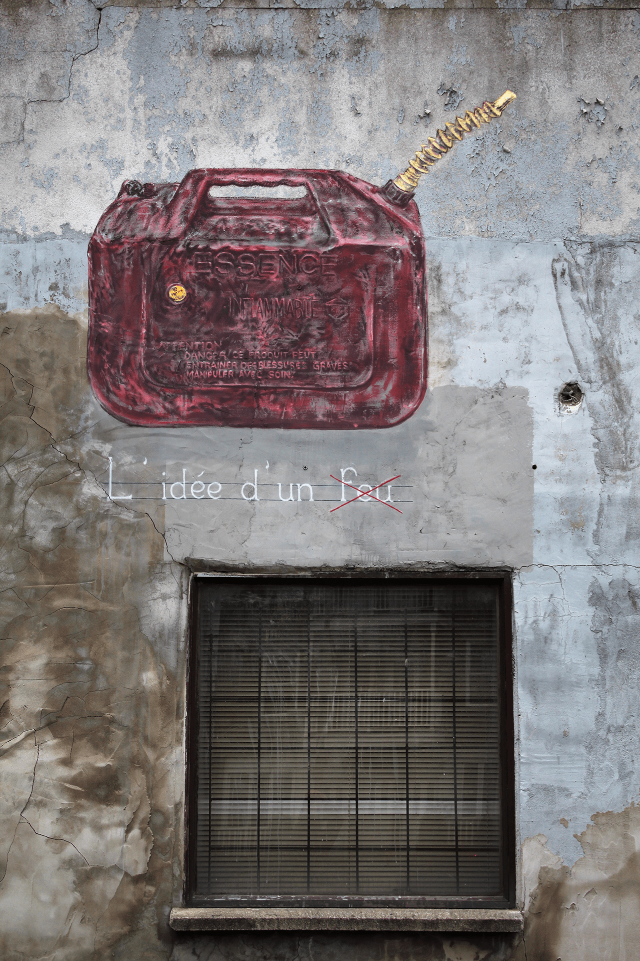 A mural depicting a red gas can with a spout, accompanied by the text 'L'idée d'un feu' on a weathered wall.